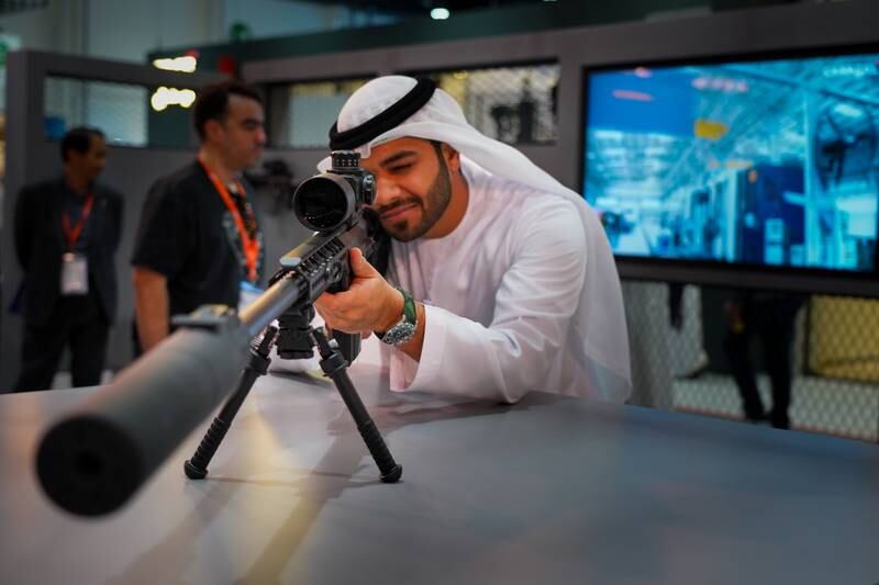 Visitors try out a sniper rifle scope sight on the first day of Idex in Abu Dhabi. AFP