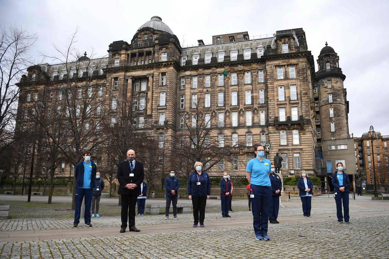 Health workers from the Glasgow Royal Infirmary take part in a minutes silence. AFP