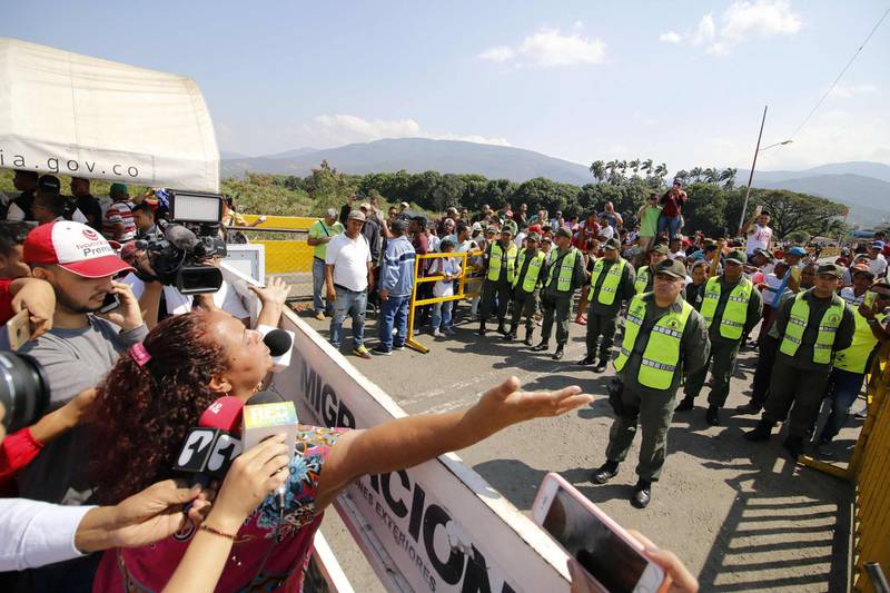 Venezuelan police block the Simon Bolivar International Bridge as Venezuelans coming from the Colombian border city of Cucuta take part in a protest against Venezuelan President Nicolas Maduro, who recently started his second term, on January 23, 2019. 
 Venezuelan opposition leader Juan Guaido declared himself interim president Wednesday, while hundreds of thousands of Venezuelans poured onto the streets to demand an end to the government of Nicolas Maduro. / AFP / SCHNEYDER MENDOZA
