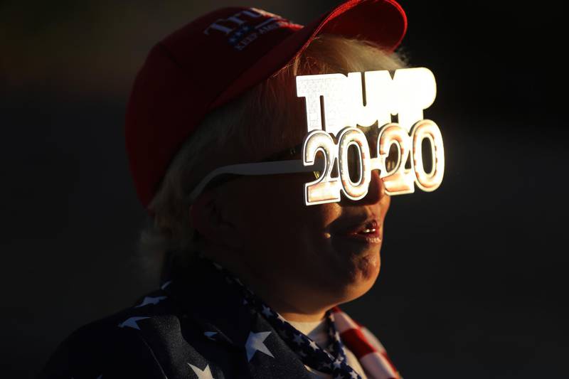 Tara Immen of Happy Valley, Arizona, wears decorative glasses while waiting in line to attend a campaign rally with U.S. President Donald Trump at Phoenix Goodyear Airport.  AFP