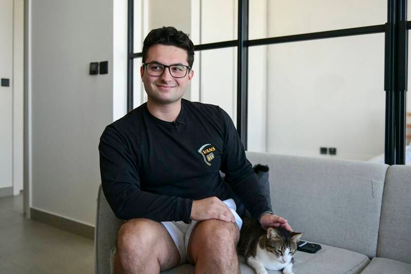 Toby Shaw, 24, with his cat Muteena in his one-bedroom flat at Dubai Hills Estate. All photos: Khushnum Bhandari / The National
