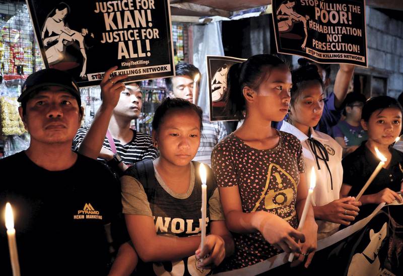 Protesters and residents hold lighted candles and placards at the wake of Kian Loyd delos Santos, a 17-year-old high school student, who was among the people shot dead last week in an escalation of President Rodrigo Duterte's war on drugs in Caloocan city, Metro Manila, Philippines August 25, 2017. REUTERS/Dondi Tawatao - RC1B3FE828F0
