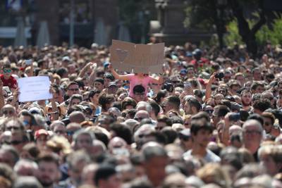 A girl holds a banner as people observe a minute of silence in Placa de Catalunya, a day after a van crashed into pedestrians at Las Ramblas in Barcelona, Spain August 18, 2017. REUTERS/Sergio Perez