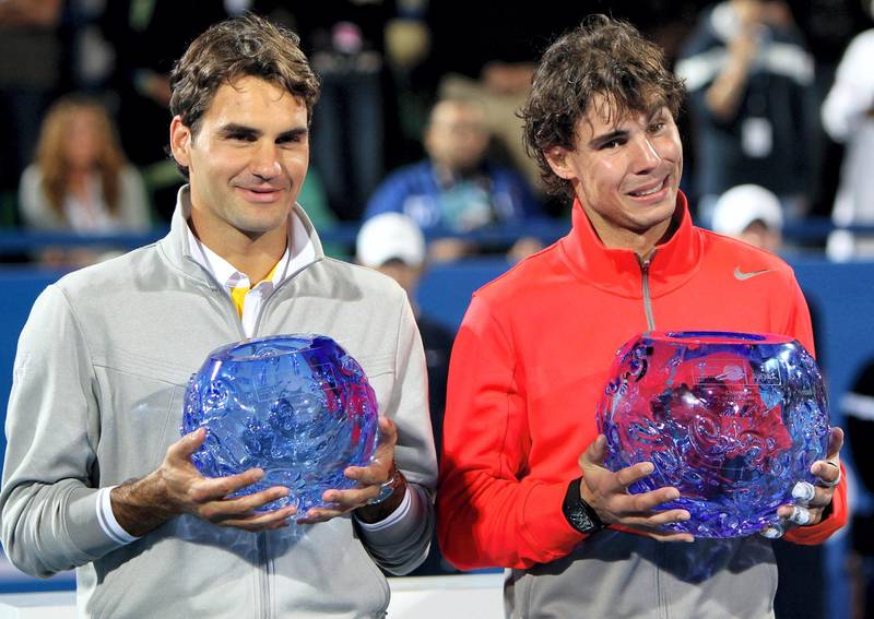 Tennis icons world number one Rafael Nadal (R) of Spain and Switzerland's Roger Federer pose with their trophies at the end of their Mubadala World Tennis Champhionship final match in Abu Dhabi on January 1, 2011. Nadal won the world tennis championship exhibition tournament after beating world number two Federer 7-6, 7-6.   AFP PHOTO/MARWAN NAAMANI (Photo by MARWAN NAAMANI / AFP)
