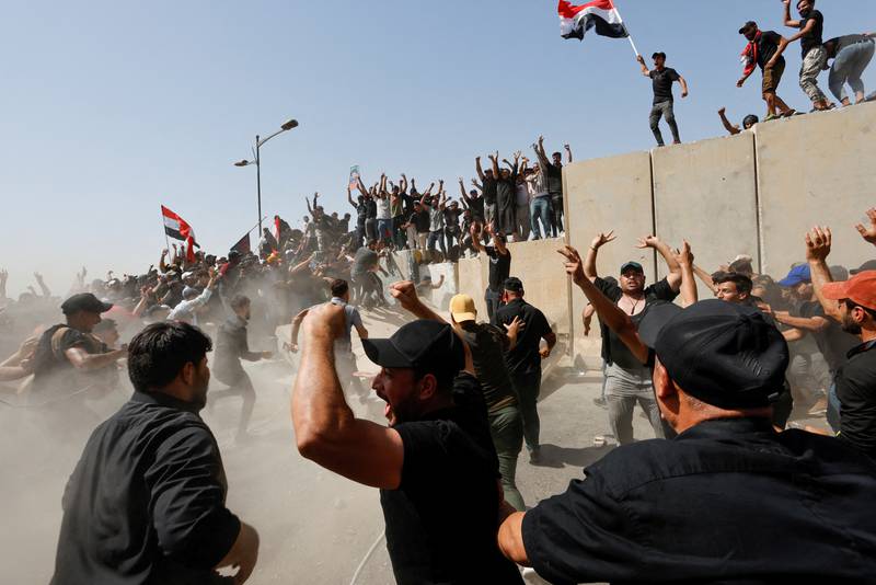 Supporters of Iraqi Shiite cleric Moqtada Al Sadr protest against corruption on the walls of the Green Zone in Baghdad on Saturday. Reuters 