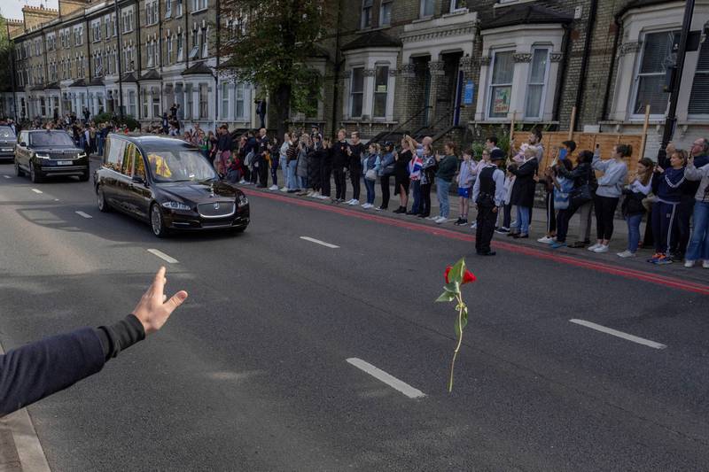 A mourner throws a flower towards Queen Elizabeth's hearse as it is driven to Windsor from London. Reuters