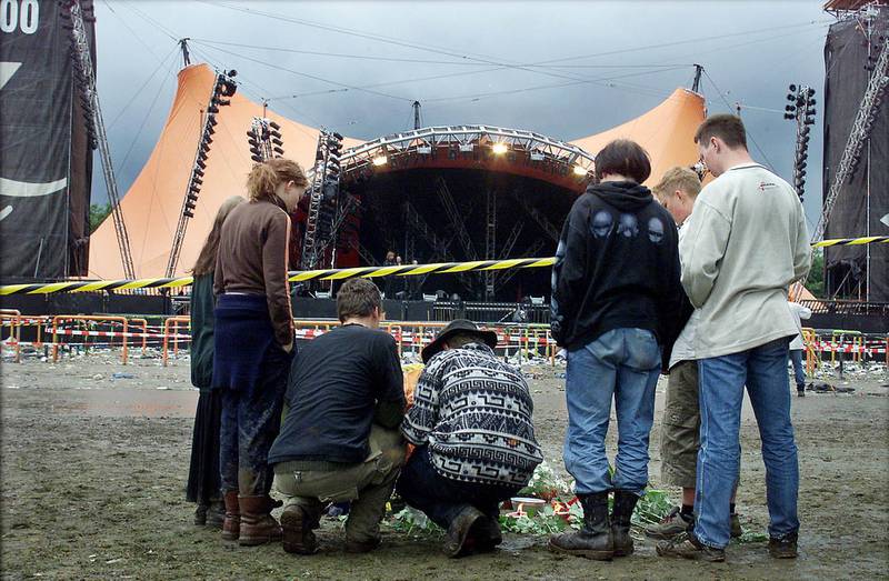 Young people lay down flowers on the grounds of the Roskilde music festival on July 1, 2000, following a fatal incident. The festival in western Denmark was hit by the first tragedy in its 30-year history when eight people were crushed and trampled to death in a crowd surge as American group Pearl Jam were playing on the main stage. AFP
