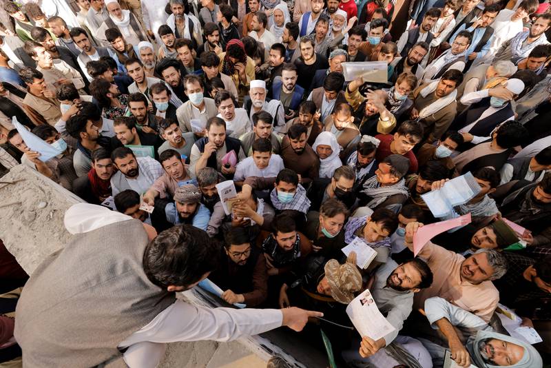 Afghans gather outside a passport office on October 6 after the Taliban said they would start issuing travel documents again. Reuters