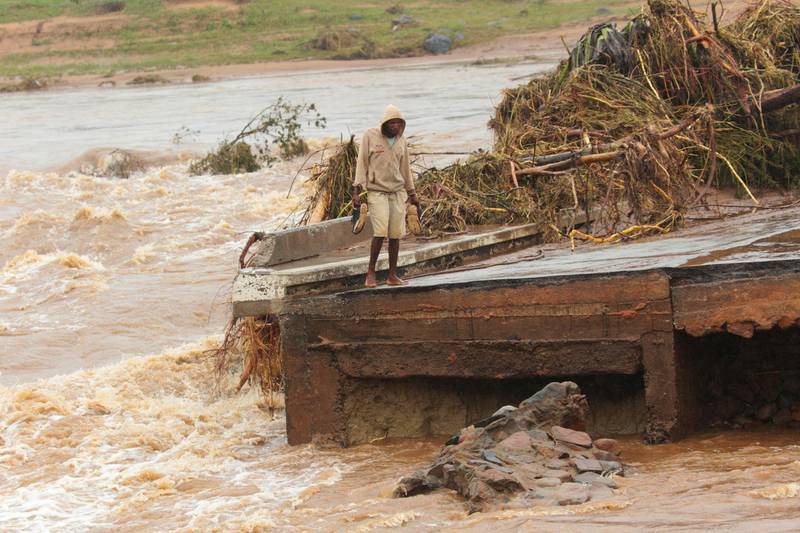 A man stands on the edge of a collapsed bridge in Chimanimani, about 600km southeast of Harare, Zimbabwe. AP Photo