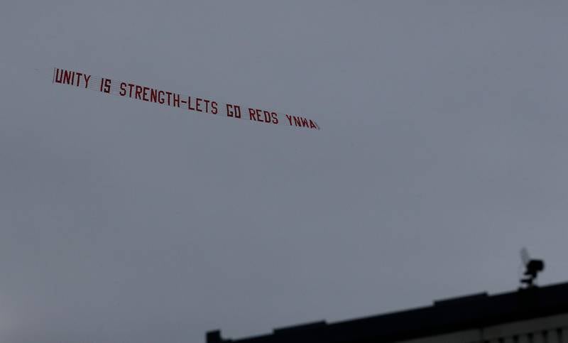 2021 A plane flies over the stadium displaying banner reading 'unity is strength - let's go Reds YNWA'. Reuters