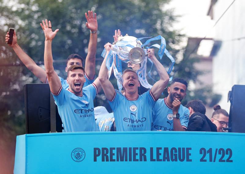 Manchester City's Oleksandr Zinchenko, Riyad Mahrez and Ruben Dias celebrate with the Premier League trophy during the victory parade on Monday, May 23. Reuters