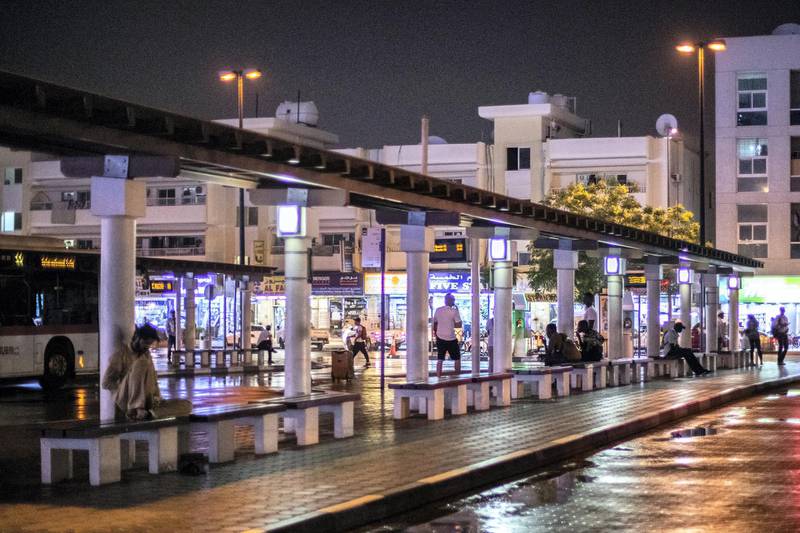 DUBAI, UNITED ARAB EMIRATES - May 17 2019.Men stand by Satwa's bus station on a rainy evening in Dubai .(Photo by Reem Mohammed/The National)Reporter: Section: NA