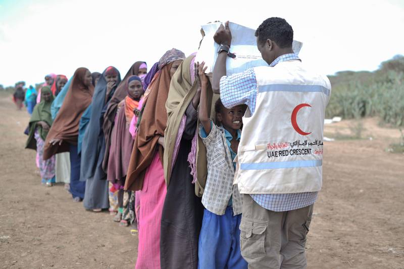 epa03813472 A handout picture provided the African Union / United Nations Information Support Team on 05 August 2013 shows a young boy receiving a box of food from a UAE Red Crescent employee at a distribution center in Afgoye, Somalia, 04 August 2013. The UAE Red Crescent gave out food aid as part of a program they are conducting during the month of Ramadan. Over 5,000 internally displaced people were given food during the NGO's trip to Afgoye, which was aided in part by African Union Mission in Somalia (AMISOM) forces.  EPA/TOBIN JONES / AU UN IST / HANDOUT MANDATORY CREDIT AU UN IST PHOTO / TOBIN JONES HANDOUT EDITORIAL USE ONLY/NO SALES *** Local Caption ***  03813472.jpg