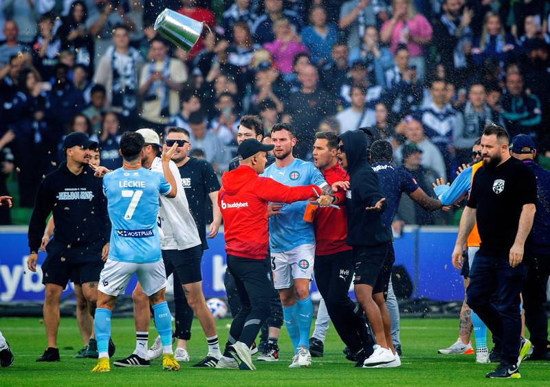 Melbourne City players look concerned as fans invade the pitch during the match. AAP