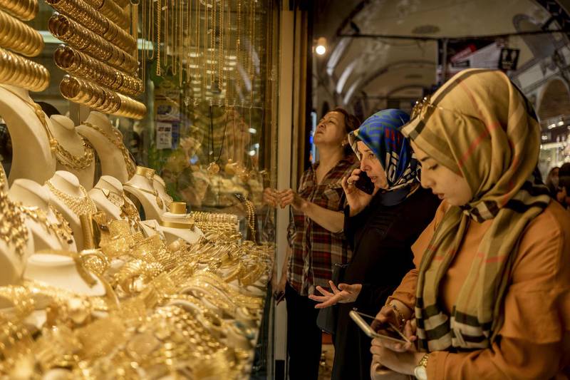 Customers browse gold jewelry in the window of a store in the Grand Bazaar in Istanbul, Turkey, on Friday, Aug. 10, 2018. A plunge in the lira sent tremors through global markets on Friday as tensions flared between the U.S. and Turkey, a pair of NATO allies. Photographer: Ismail Ferdous/Bloomberg