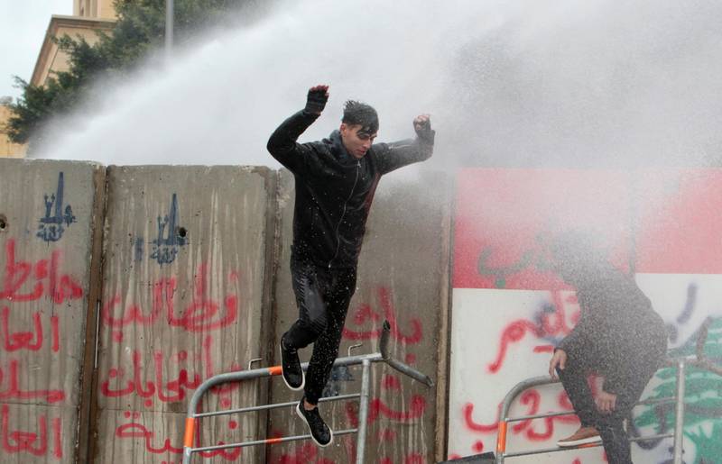 A demonstrator is sprayed with a water cannon during a protest seeking to prevent MPs and government officials from reaching the parliament for a vote of confidence, in Beirut, Lebanon. REUTERS