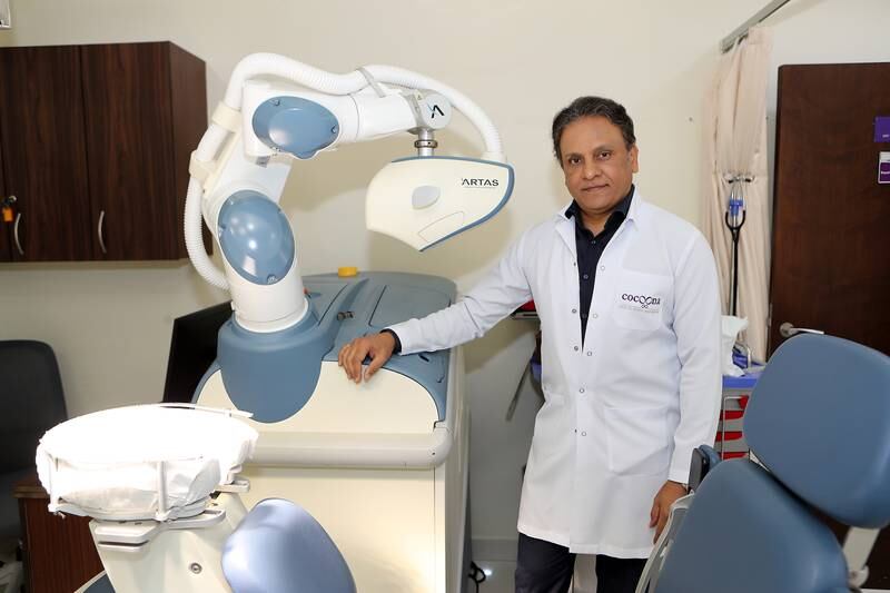 Dr Sanjay Parashar with the robotic transplant machine at the Cocoona clinic in Dubai. Pawan Singh / The National