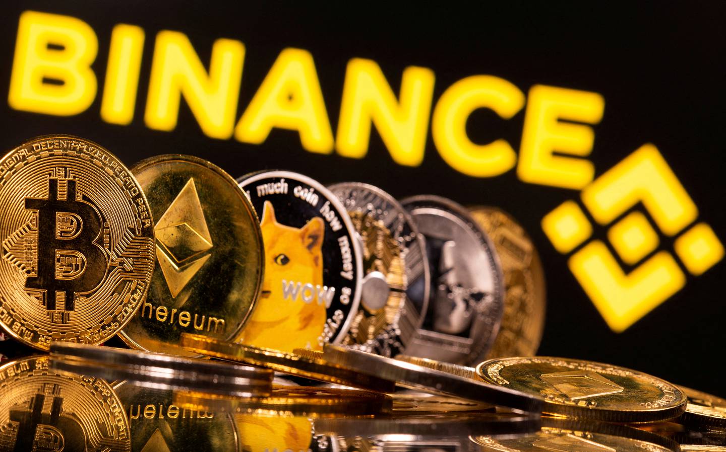Cryptocurrencies Bitcoin, Ethereum, DogeCoin, Ripple, and Litecoin in front of a Binance logo. Reuters 