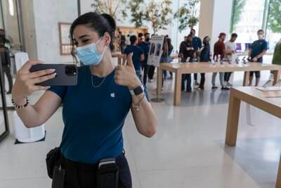 An Apple shop worker shows off the new model.