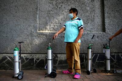 A man queues to fill oxygen in a tank for a relative due to an increase in coronavirus disease infection rates in Mexico, outside a medical supply store in Mexico City. Reuters
