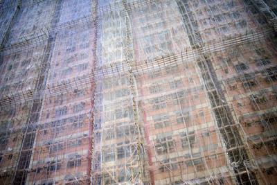 Bamboo scaffolding and meshing is seen over a residential complex in Hong Kong on September 6, 2014. Housing prices in the southern Chinese city have roughly doubled since 2009, with prices being pushed up by buyers from mainland China. Alex Ogle / AFP