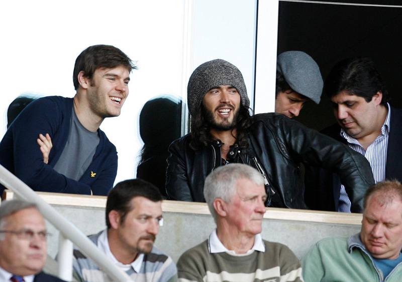 Entertainer Russell Brand (R) watches the match between West Ham United and Sunderland during their Premier League football match at Upton Park in London, England on April 4, 2009. AFP PHOTO/IAN KINGTON - FOR EDITORIAL USE ONLY Additional licence required for any commercial/promotional use or use on TV or internet (except identical online version of newspaper) of Premier League/Football League photos. Tel DataCo +44 207 2981656. Do not alter/modify photo. (Photo by IAN KINGTON / AFP)