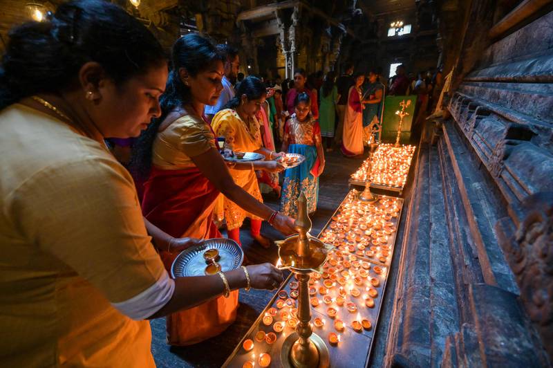 Devotees light oil lamps and offer prayers on New Year's Day at a Hindu temple in Colombo, Sri Lanka. AFP
