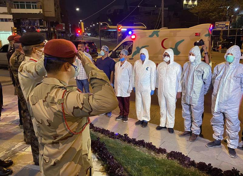 Iraqi Army officers salute to a group of doctors and medical staff in central Baghdad, Iraq. AP Photo