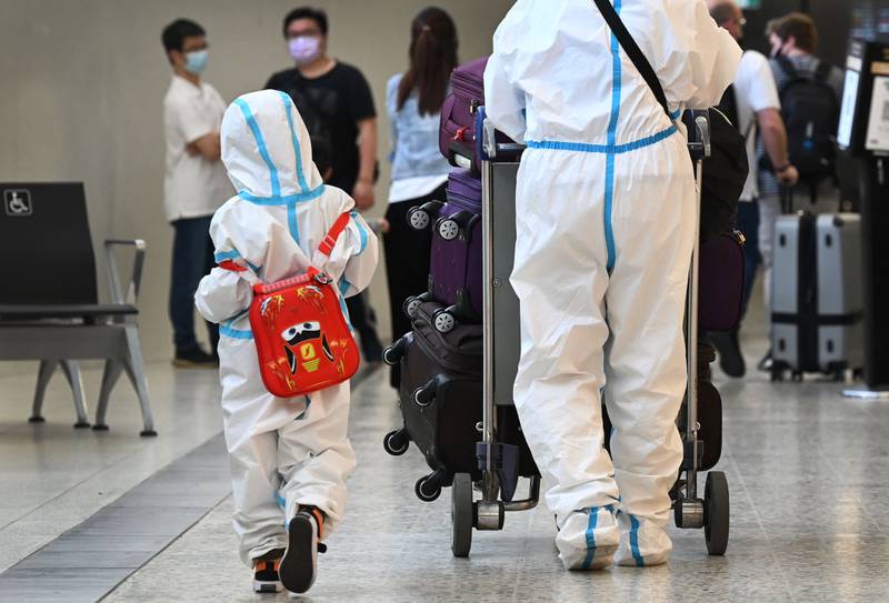 International travellers wearing personal protective equipment arrive at Melbourne's Tullamarine Airport as Australia records its first cases of the Omicron variant. AFP