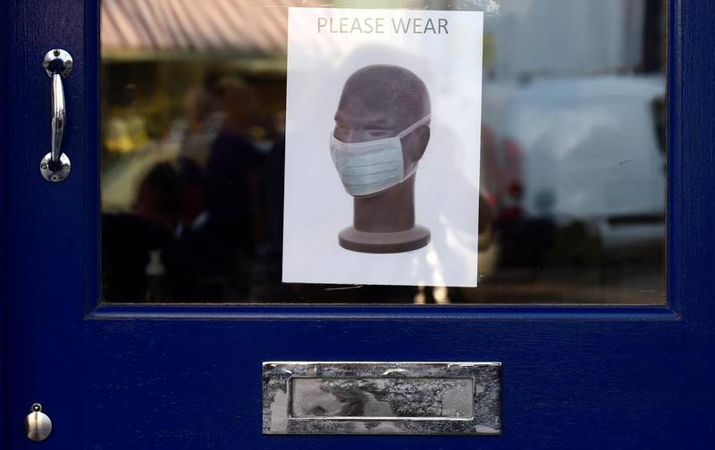 A poster is seen on a door requiring to wear a mask in Tenby, Wales. Reuters