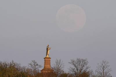 A full pink supermoon rising behind a statue of the Christ in Wolxheim, France. AFP