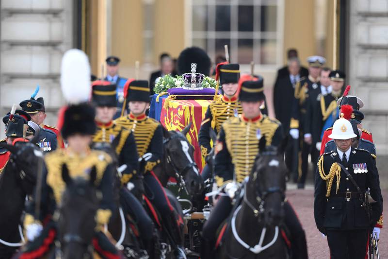 The coffin of Queen Elizabeth, adorned with the royal standard and the imperial state crown, and pulled by a gun carriage of the King's Troop Royal Horse Artillery, during the procession from Buckingham Palace in London. AFP