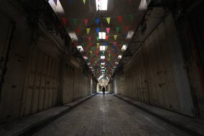 epa08360794 Palestinians walk in empty street inside al-Tujjar caravanserai in the West Bank city of Nablus, 13 April 2020.  Nablus was closed due to the current novel coronavirus emergency after the Palestinian National Authority (PA) has imposed a new 14-day period of home confinement for all Palestinians living in the West Bank amid the ongoing pandemic of the COVID-19 disease caused by the SARS-CoV-2 coronavirus.  EPA/ALAA BADARNEH