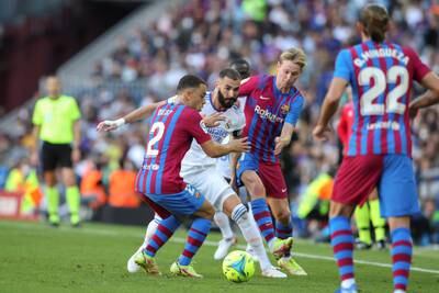 Karim Benzema gets crowded out by Barcelona players. EPA
