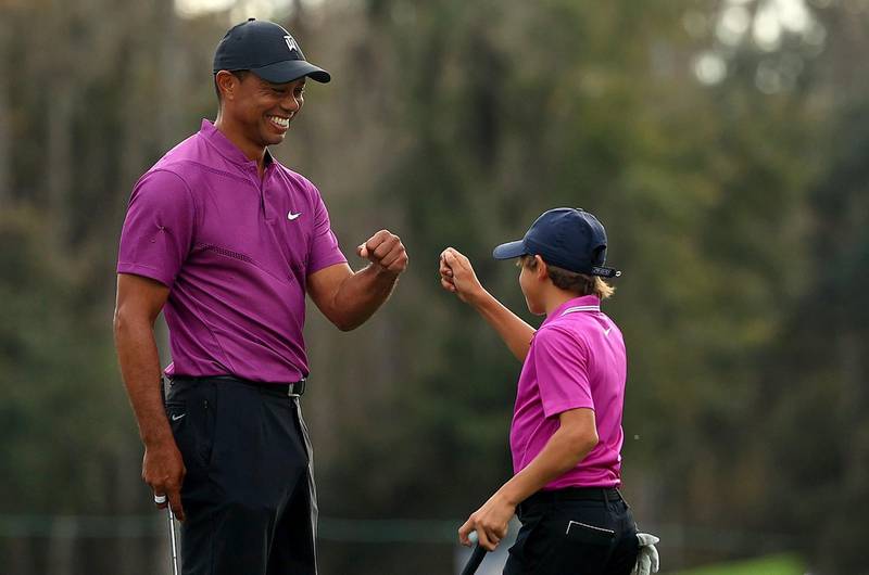 Tiger Woods and son Charlie Woods high five after a birdie on the ninth hole. AFP