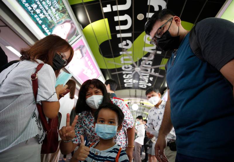A Malaysian tourist family wears protective masks as walk at a skytrain station in Bangkok, Thailand.  EPA