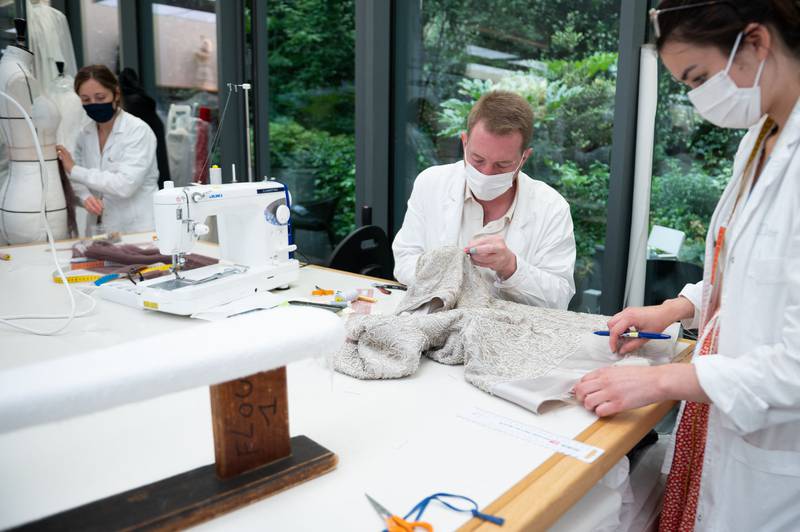 Employees works on the haute couture collection at the Christian Dior headquarters in Paris on July 3, 2021.