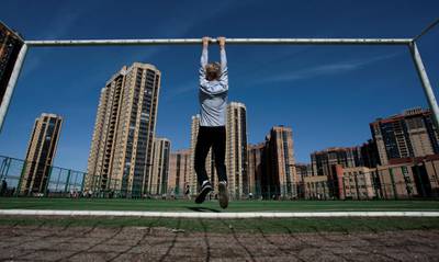 A boy hangs from a goalpost in St Petersburg, Russia. Anton Vaganov / Reuters