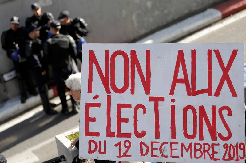 A group of police officers are pictured next a poster reading "No to the Dec.12 2019 elections" during a protest in Algiers. AP Photo