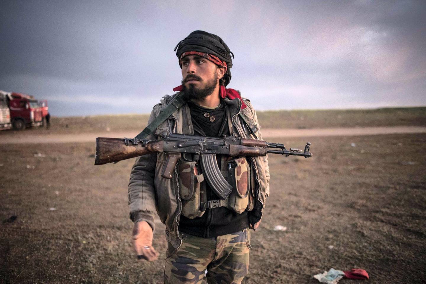 An SDF fighter waits for surrendering ISIS members outside Baghouz ,Syria, 7 March 2019.