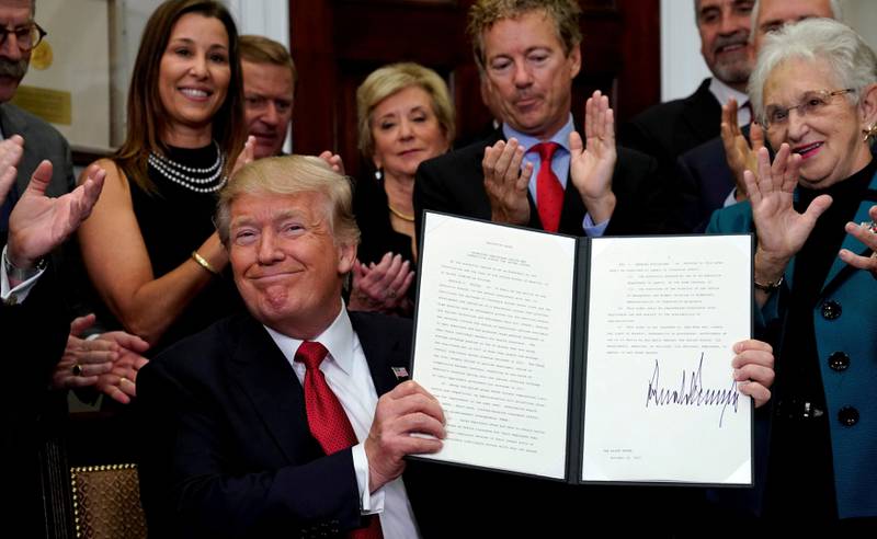 FILE PHOTO: U.S. President Donald Trump smiles after signing an Executive Order to make it easier for Americans to buy bare-bone health insurance plans and circumvent Obamacare rules at the White House in Washington, U.S. on October 12, 2017.  REUTERS/Kevin Lamarque/File Photo