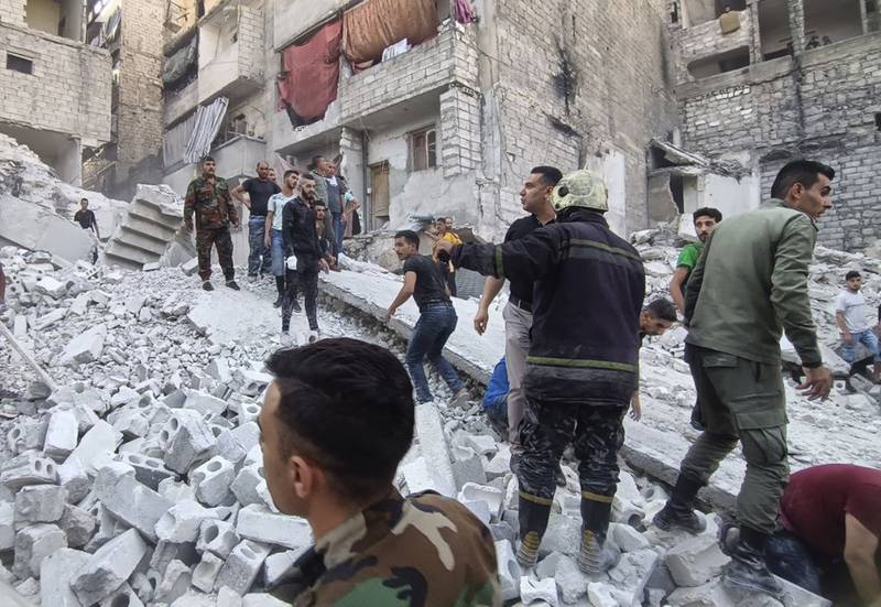 Syrian Civil Defense workers and security forces work on the rubble of a destroyed building, in Aleppo, Syria. AP
