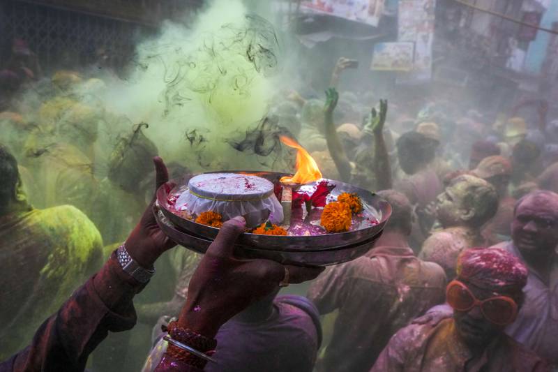 Hindu devotees with offerings make their way through Holi revellers, in Kolkata. AP
