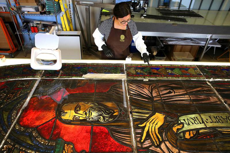 French glassmaker Flavie Vincent-Petit works on cleaning stained glass windows from Notre-Dame Cathedral in Paris at her workshop in the town of Troyes, north-eastern France. The windows are scheduled to be reinstalled by next spring. AFP