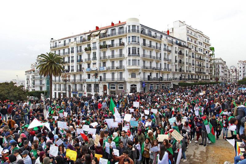 TOPSHOT - Algerians carry placards and national flags as they take part in a demonstration in the capital Algiers against President Abdelaziz Bouteflika on March 19, 2019.  Bouteflika today confirmed he will stay in power beyond his term expiring next month, despite tens of thousands of people demonstrating against his rule. / AFP / STRINGER
