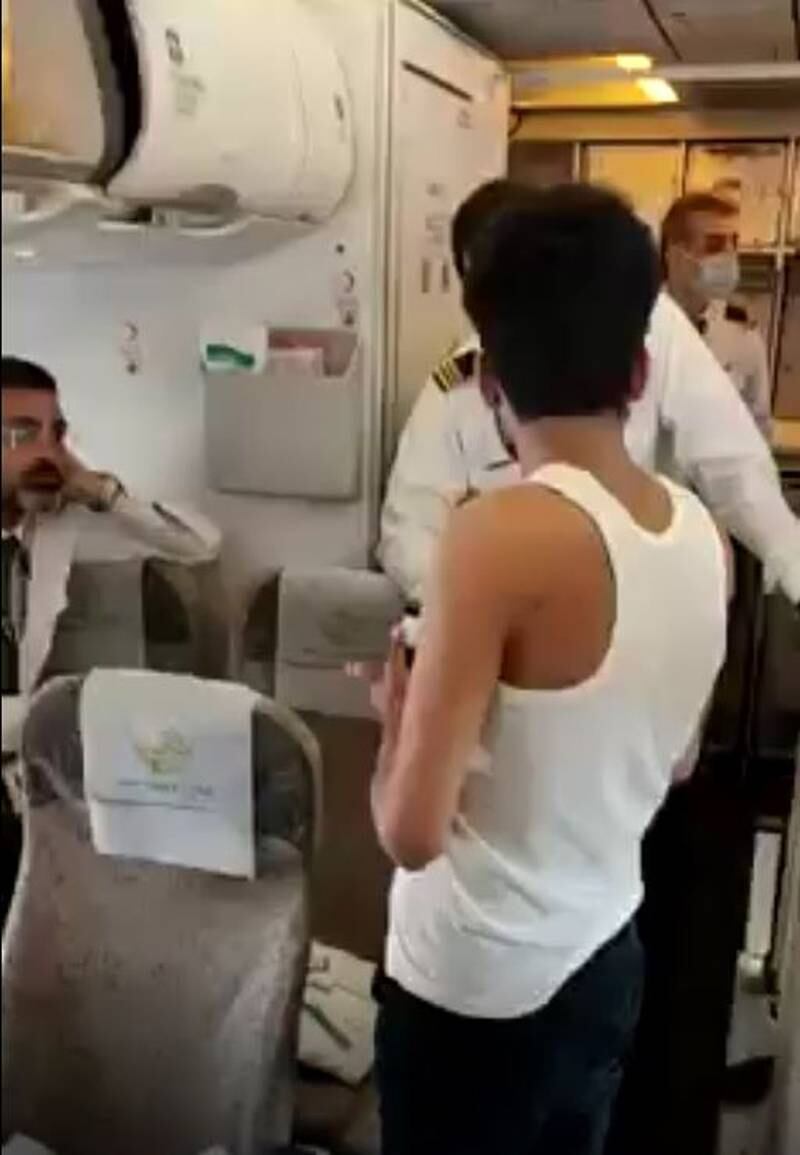 A passenger confronts a crew member on a Peshawar to Dubai flight on Wednesday, September 14. The airline said he kicked a window before they were forced to tie him to a seat. Photo: Pakistan International Airlines