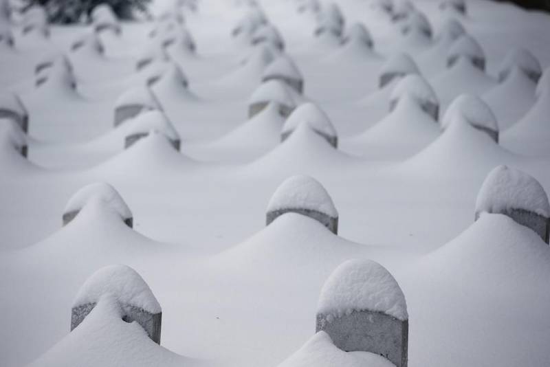 Headstones are nearly covered by snow at Arlington National Cemetery, in Arlington, Virginia. A blizzard with hurricane-force winds brought much of the East Coast to a standstill Saturday, dumping as much as 3 feet of snow, stranding tens of thousands of travelers and shutting down the nation’s capital and its largest city. Alex Brandon / AP