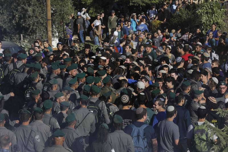 Israeli settlers scuffle with Israeli security forces at Netiv Haavot settlement. Menahem Kahana / AFP