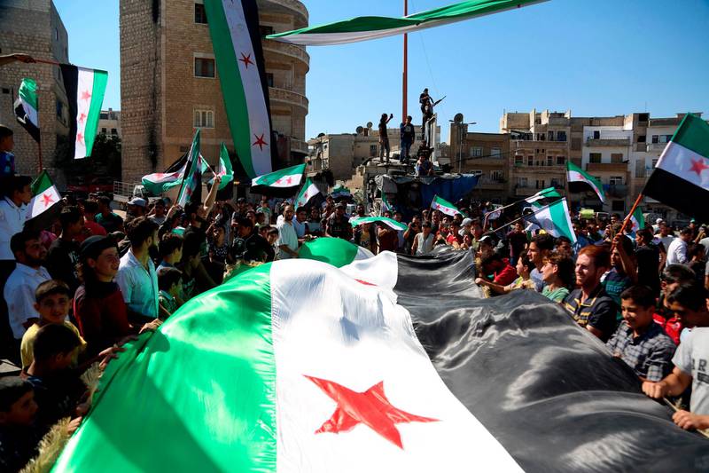 Syrian protesters, wearing the colours of opposition, attend an anti-government demonstration in the rebel-held northern Syrian city of Idlib on September 28, 2018.  / AFP / Zein Al RIFAI
