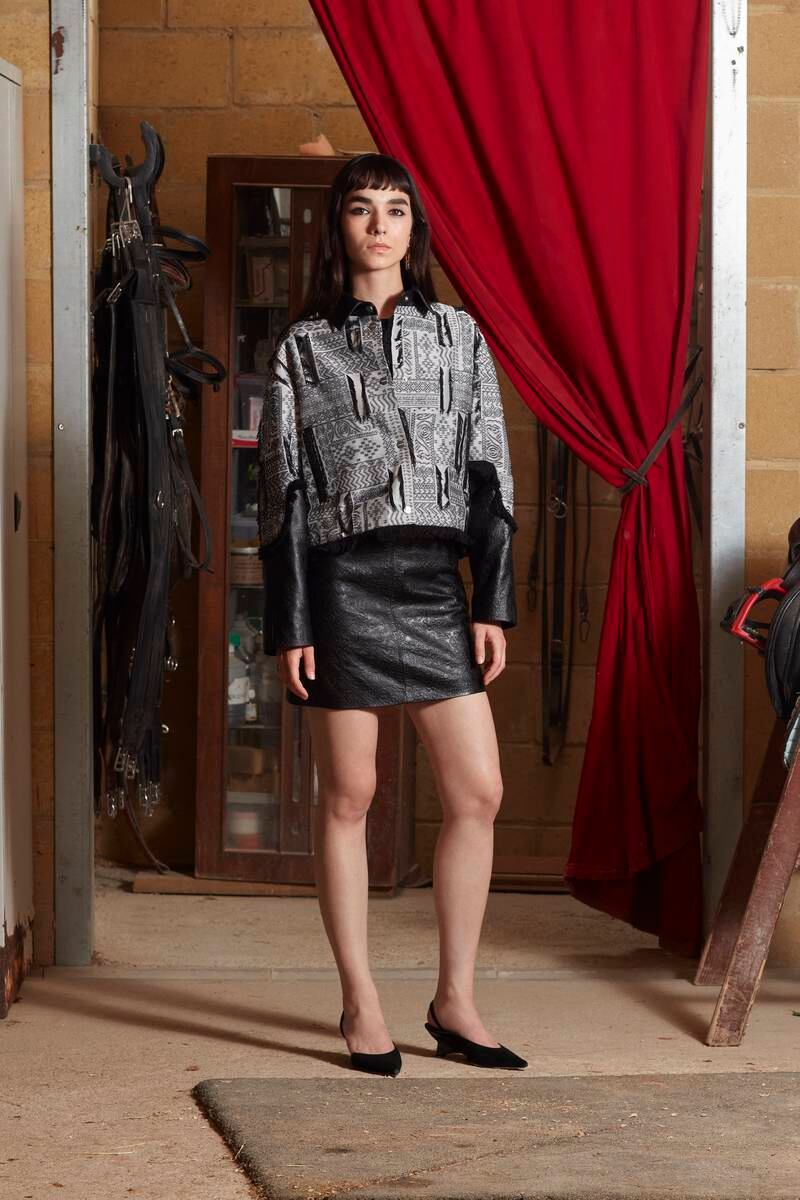 An embossed leather skirt is teamed with a collared jacket made from fabric that draws on the intricate patterning of Turkish carpets and kilims. 